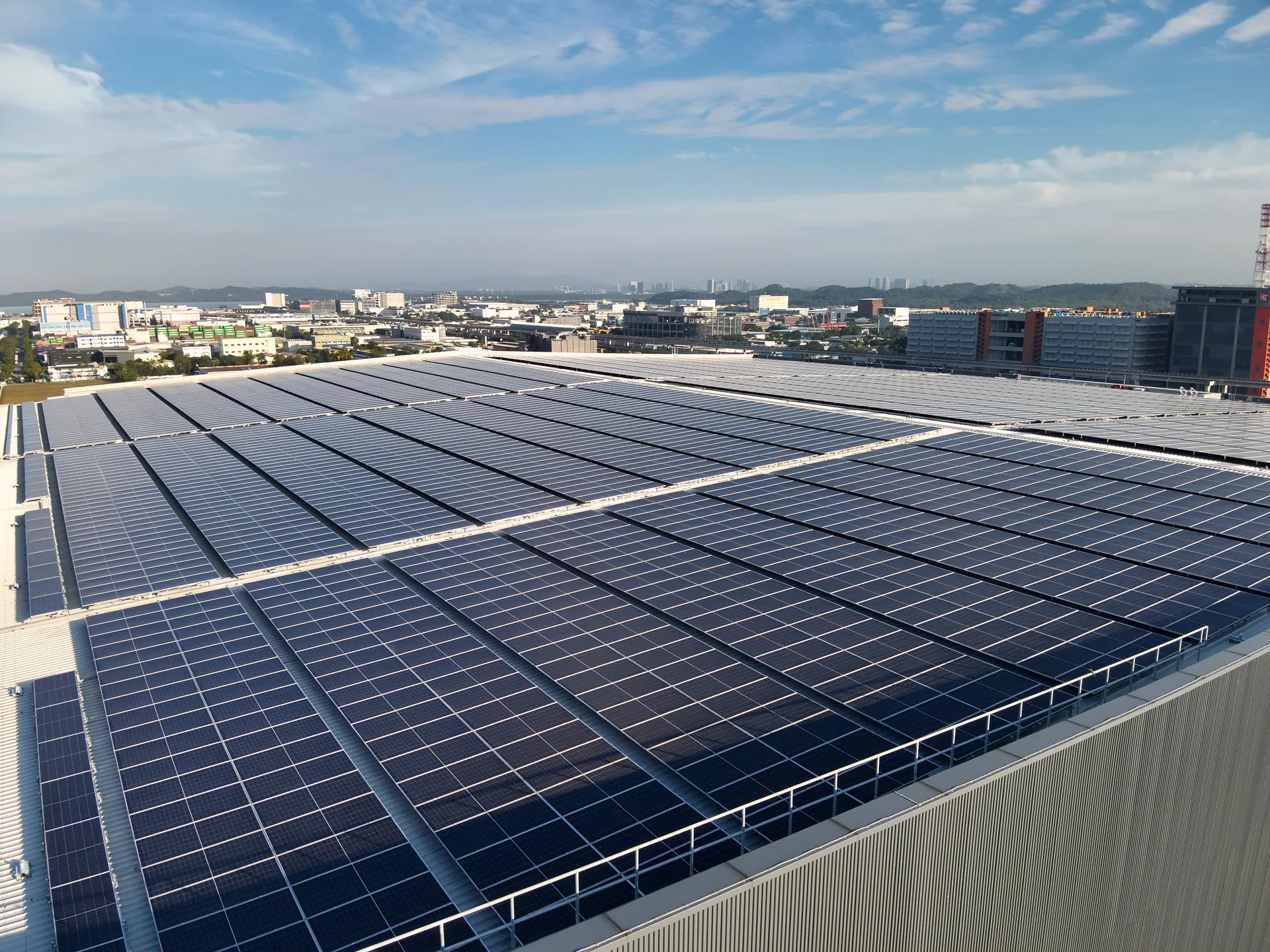 80+ MWp solar capacity delivered — Boustead 36 Tuas Road industrial rooftop array against Singapore Strait skyline
